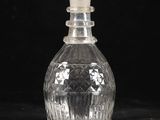 une bouteille en verre transparent munie d'un bouchon, posée sur une surface noire