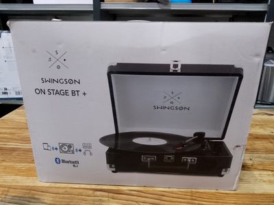 the box of a record player sits on a table in a store