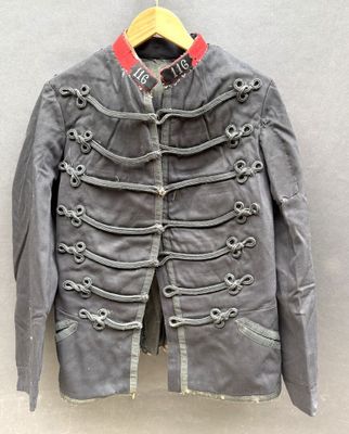 une veste grise suspendue à un cintre accroché au mur