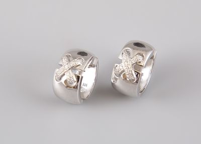 une paire de boucles d'oreilles en argent et diamants sur fond blanc