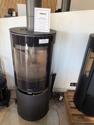 a wood burning stove in a room with a sign on the wall
