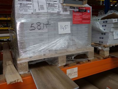 une palette remplie de cartons, placée sur une autre palette dans un entrepôt