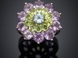 a close up of a purple and green flower ring on a black surface