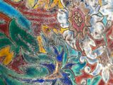 a close up of a colorful vase with flowers painted on it