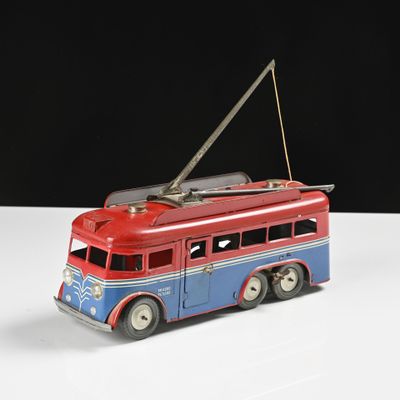 un petit bus rouge et bleu posé sur une surface blanche