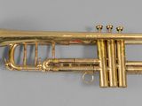an old brass trumpet sitting on top of a gray surface