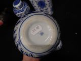 someone is holding a blue and white vase with a tag on it