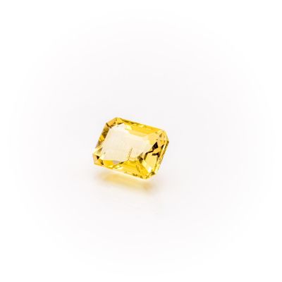 a yellow sapphire stone on a white background