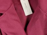 un gros plan d'un manteau rose suspendu à un cintre