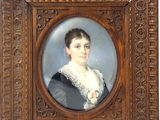 portrait d'une femme en robe noire dans un cadre en bois
