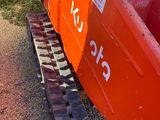 a red boat sitting on the side of the road