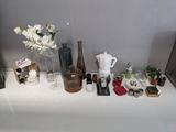 une table blanche sur laquelle sont disposées des bouteilles et des vases remplis de produits de beauté
