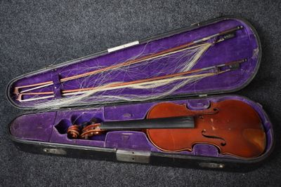 un violon dans un étui violet posé sur une surface noire