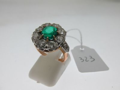 gros plan d'une bague avec une pierre verte entourée de diamants