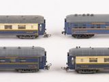 four blue and gold train cars sitting on top of a white surface