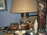 a table with a lamp, a book, and a statue on it