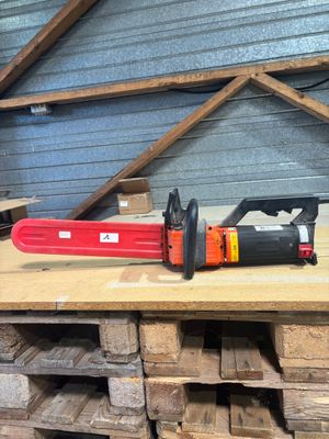a chainsaw sitting on top of a pallet in a warehouse