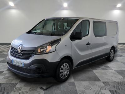 La camionnette argentée est garée sur un sol à damier dans un garage.