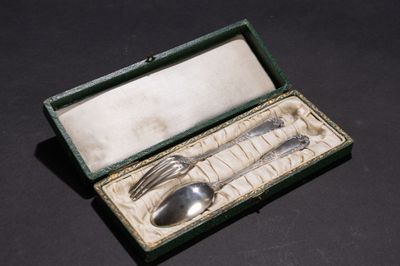 une cuillère et une fourchette en argent dans une boîte posée sur une table