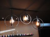 three light bulbs hanging from the ceiling above a bar