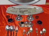 a silver tray with silverware on a red table cloth