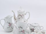 a white tea set with pink flowers on it