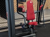 a gym room with a gym equipment set up in front of a chain link fence
