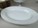 a white plate with a gold rim sitting on a table
