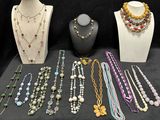 many necklaces and bracelets on display on a table