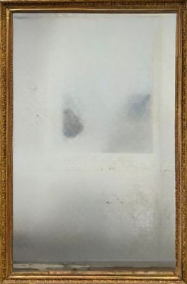 une photo d'un miroir à cadre doré accroché au mur d'une pièce