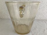 a clear glass cup with a handle on a table