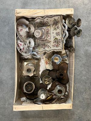 une boîte remplie d'objets divers posée par terre