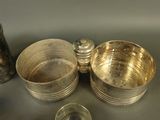 three silver bowls and two silver cups on a table