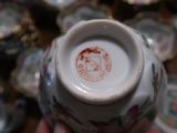 a person holding a small vase with a picture of a cat on it