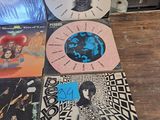 a lot of records on a table with a person standing next to them