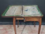 an old wooden table with a green top and two drawers