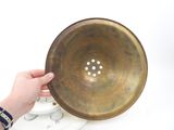 a person that is holding a metal bowl in their hand