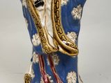 chinese figurine of a man with a blue robe holding a green vase
