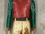 an old wooden figure of a man wearing a hat and a red shirt