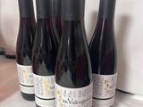 six bouteilles de vin sont alignées sur une table