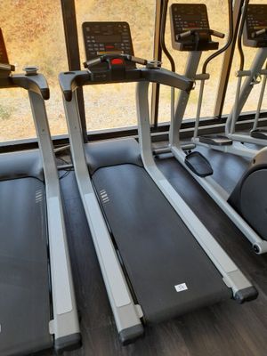 trois tapis de course alignés dans la salle de sport