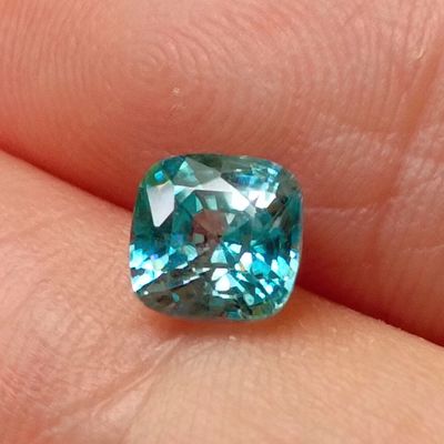 an image of a close up of a person ' s hand holding a blue diamond