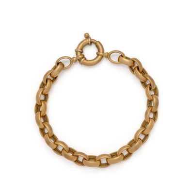 gros plan d'un bracelet en chaîne en or sur fond blanc