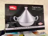 someone is holding a box that has a silver pot inside of it