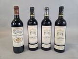 quatre bouteilles de vin sont alignées sur une table