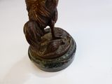 une statue représentant un ange tenant un oiseau, posée sur un socle