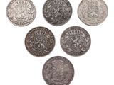 six pièces de monnaie britanniques différentes sont disposées en cercle sur un fond blanc