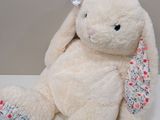 a white stuffed animal with a pink bow on it ' s head