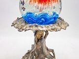 une boule de verre posée sur un socle en métal