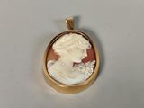 an image of a gold plated pendant with a woman ' s profile